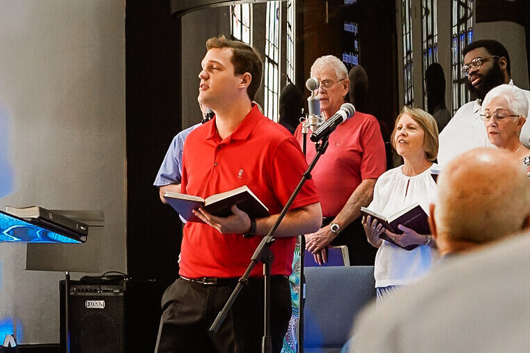 Traditional choir director Kolton Black leading the Sunday morning music