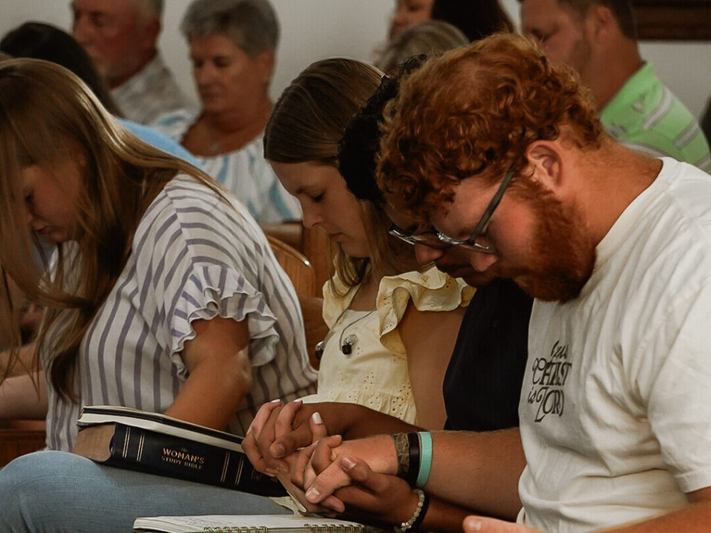 Youth who are back at church praying together